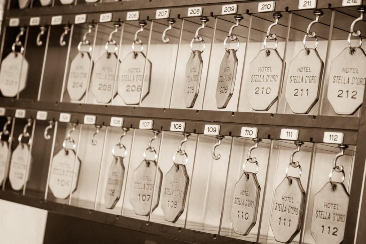 A row of hotel room tags with numbers and names, indicating room assignments.