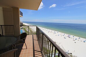 Enjoy stunning ocean views from this balcony with a table and chairs.