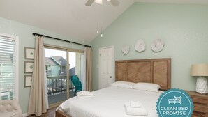 Une chambre propre et bien éclairée, avec un lit, une chaise et une vue sur l’extérieur.