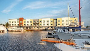 A marina with several boats docked, a building with multiple windows and balconies, and a clear sky. - Fairfield Inn & Suites by Marriott Duluth Waterfront (Duluth)