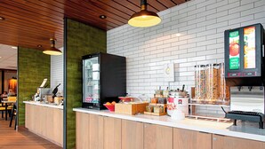 A modern breakfast bar with a wooden counter, a refrigerator, and a digital menu display. - Fairfield Inn & Suites by Marriott Duluth Waterfront (Duluth)