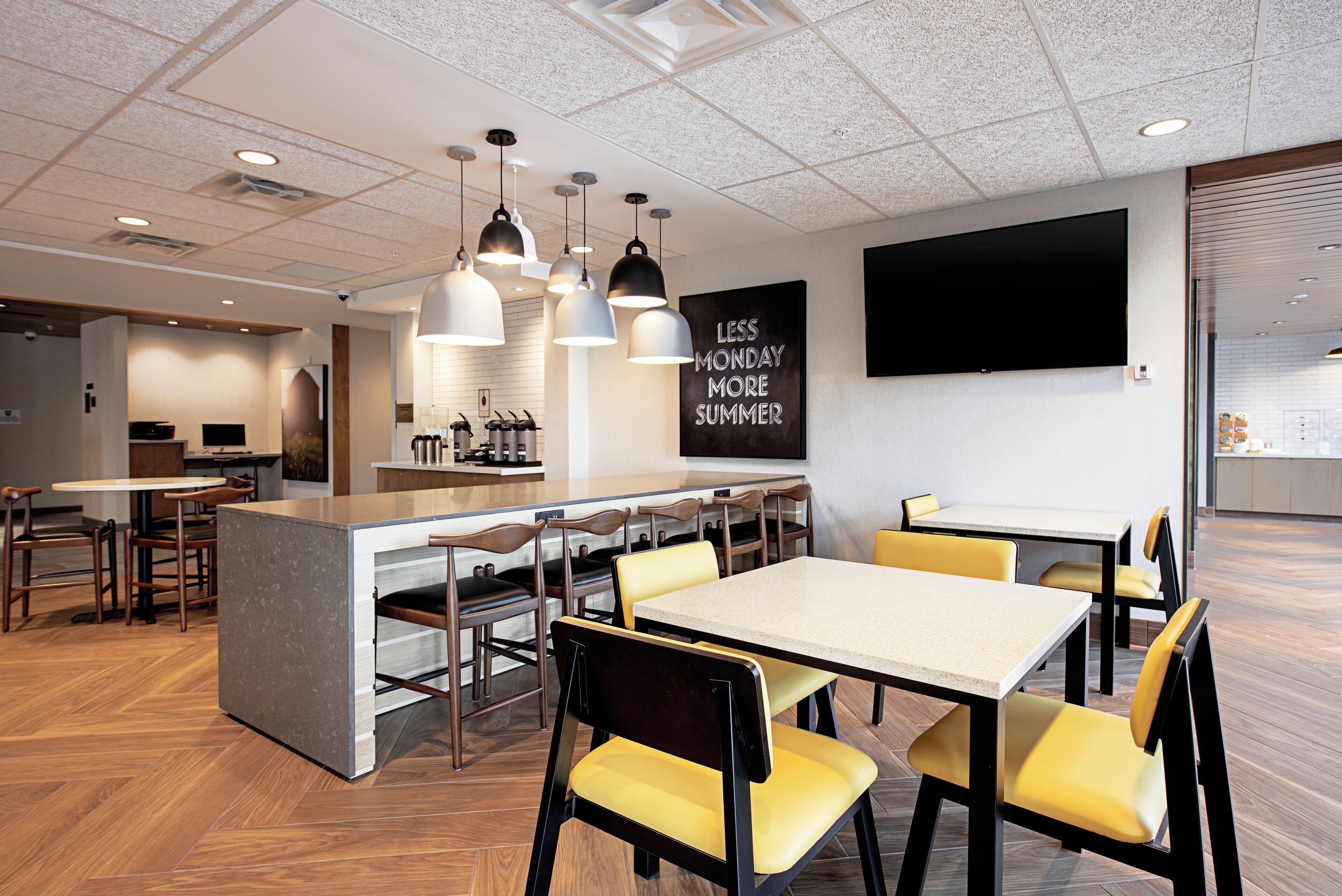 A modern dining area with a central island, multiple tables, and chairs.