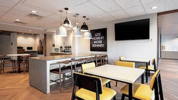 A modern dining area with a central island, multiple tables, and chairs.
