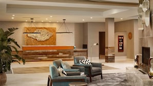 A modern lobby with a reception desk, seating area, and a fireplace. - TownePlace Suites by Marriott Louisville Northeast (Louisville)