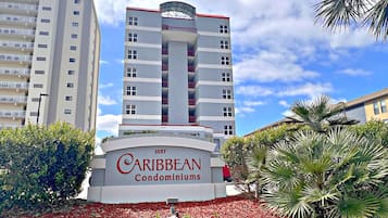 A Caribbean Condominiums building with a modern design, featuring multiple balconies and a central tower.