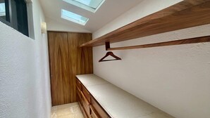 A narrow hallway with a wooden bench, a wooden door, and a wooden shelf with a hanging item.