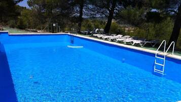 Alberca al aire libre y camastros