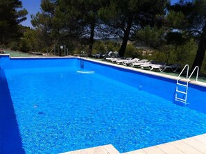 Alberca al aire libre y camastros 