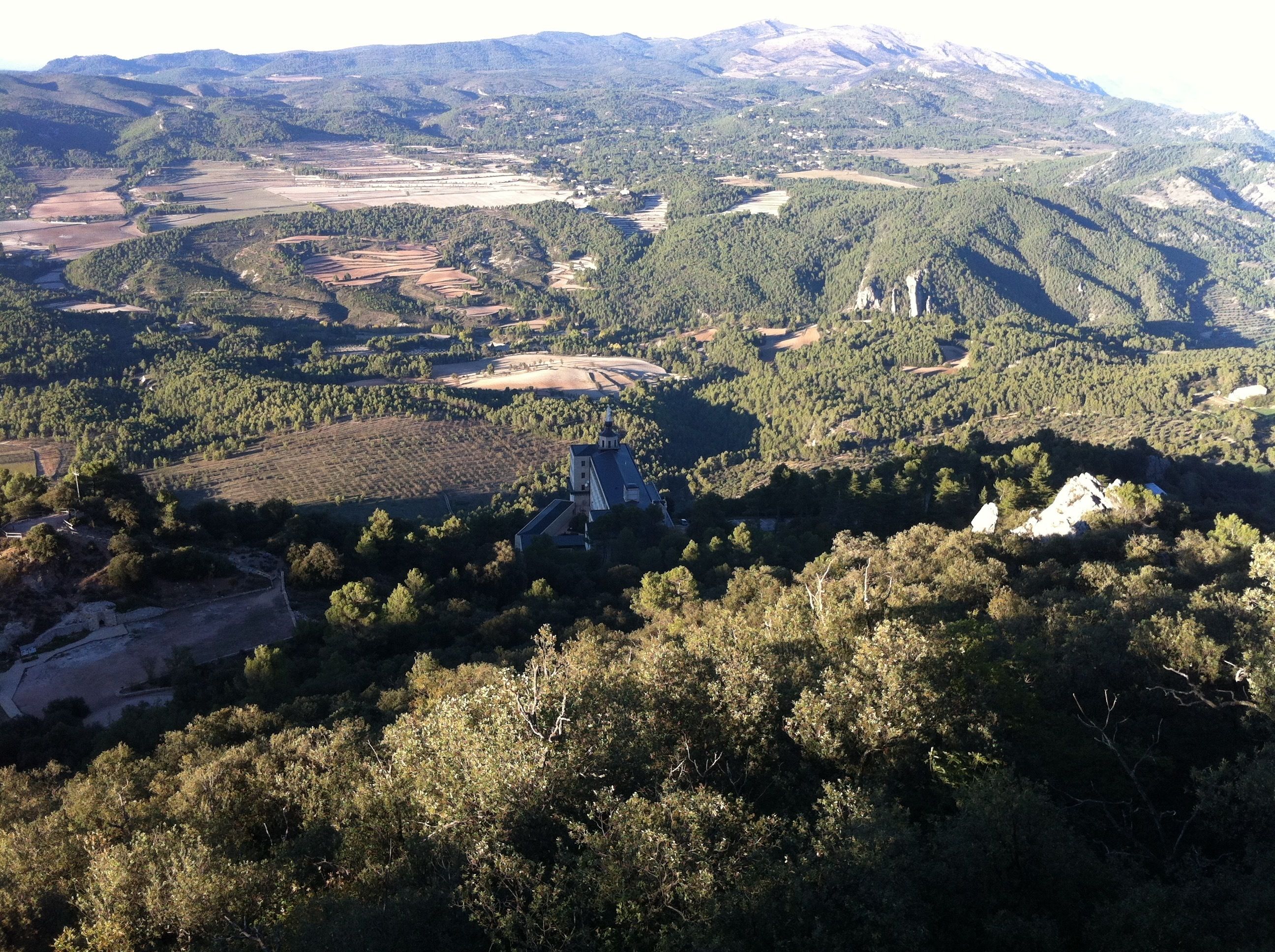 A mountainous landscape with a church and surrounding fields.