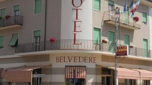 A hotel with a prominent "HOTEL" sign, balconies with flowers, and a "BAR" sign indicating on-site amenities.