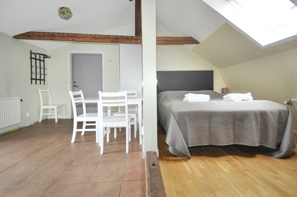 A bedroom with a bed, a table, and chairs. - Boende Visby (Visby)