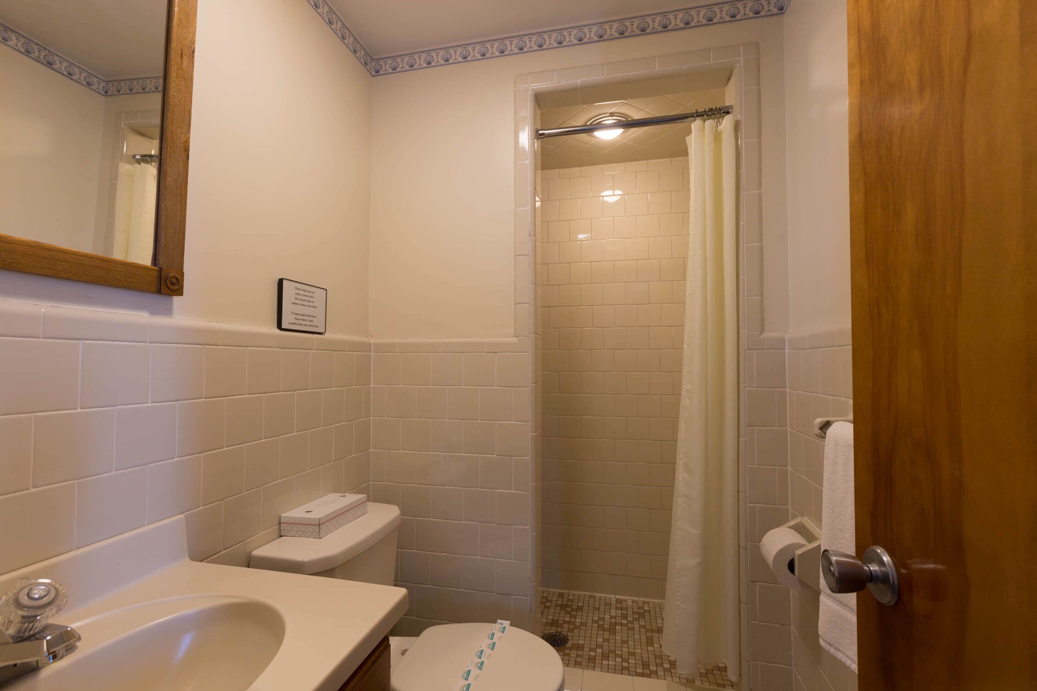 Un baño con lavamanos, inodoro y ducha.