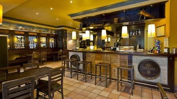 Un'area bar con sgabelli, un bancone e una vetrina piena di bottiglie.