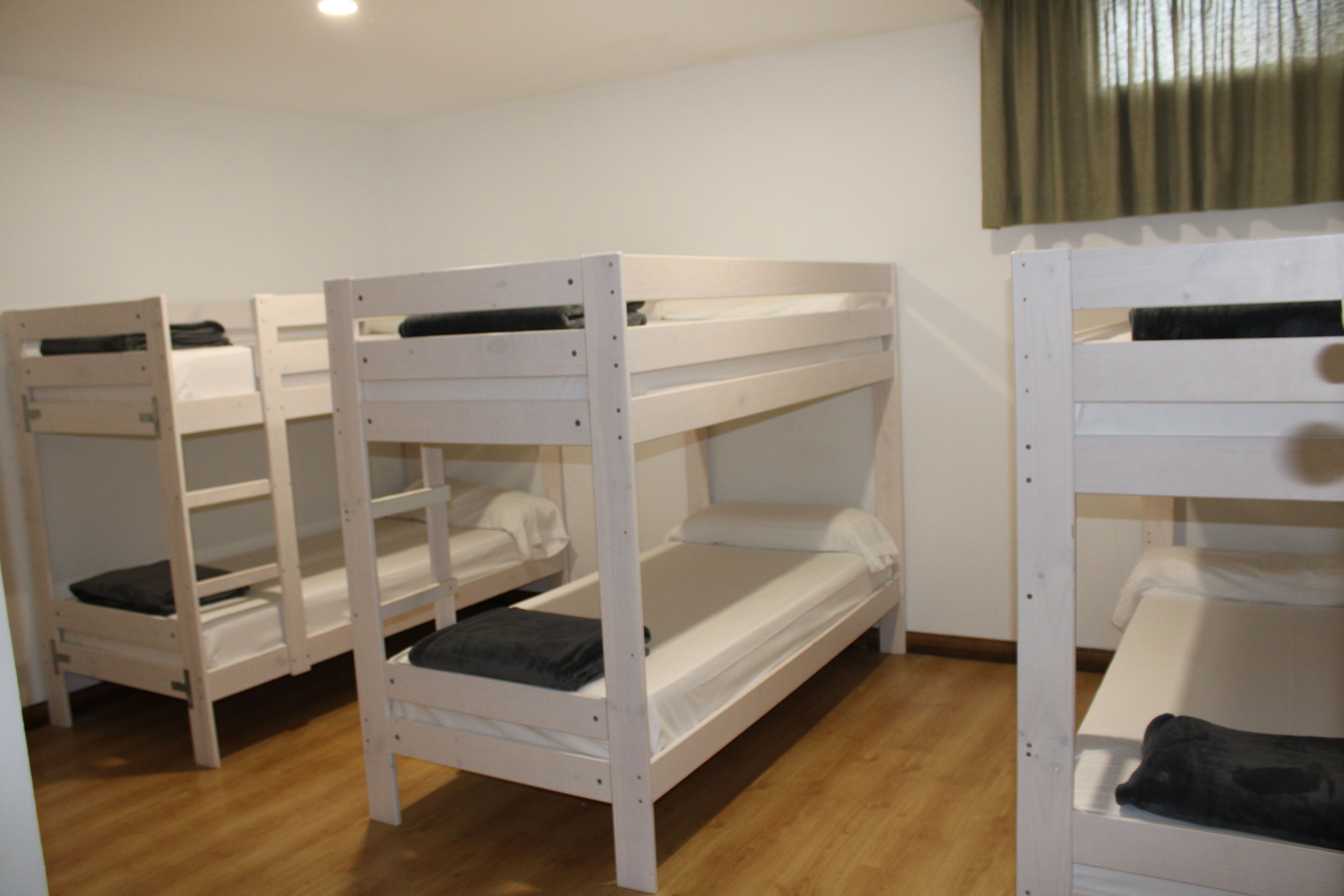 Bunk beds in a room with wooden flooring and white walls.