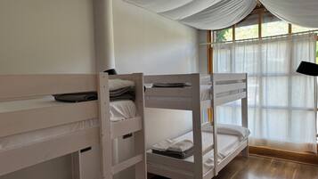 Habitación con literas, ventana y cortinas.