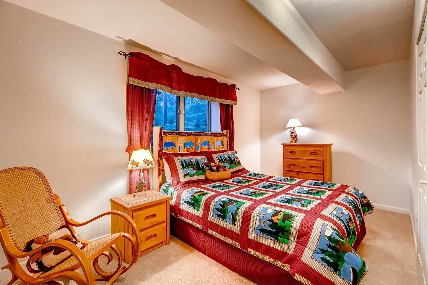 Une chambre confortable avec un lit, une chaise, une table de chevet et une commode.