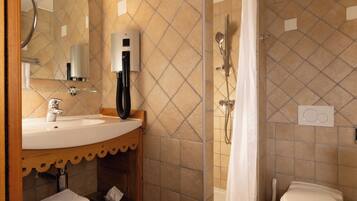 Ein Badezimmer mit Waschbecken, Spiegel, Handtuchhalter, Dusche und Toilette.
