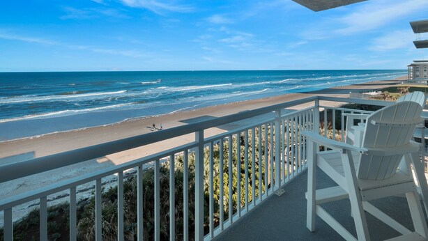 A balcony with a view of the beach and ocean. - Updated direct oceanfront 2/2 with a heated beachfront pool and beach access boardwalk (New Smyrna Beach)