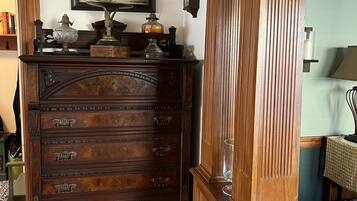 A wooden dresser with multiple drawers and a clock on top.