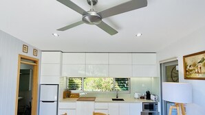 A modern kitchen with white cabinets, a built-in oven, and a large window. - Banksia Luxury Villa (Margaret River)