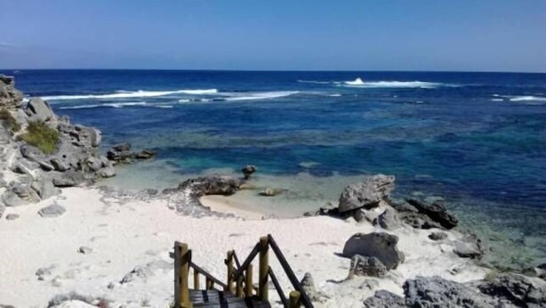 A rocky beach with clear water and a wooden staircase leading down to the shore. - Banksia Luxury Villa (Margaret River)