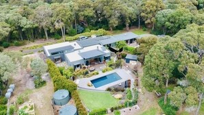 A modern house with a swimming pool, surrounded by lush greenery and trees. - Banksia Luxury Villa (Margaret River)