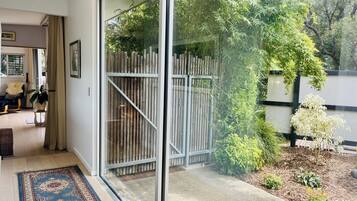 Un salon moderne doté d’une grande porte-fenêtre coulissante donnant sur un jardin.