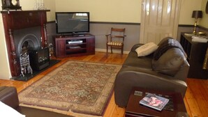 Una sala de estar con chimenea, televisor, sofá y una mesa de centro.
