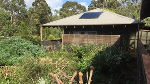 A house with a solar panel on the roof, surrounded by dense vegetation. - St Clair Cottage Peaceful romantic country getaway  (Margaret River)