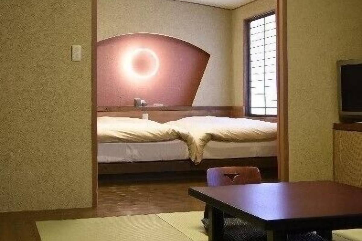 A room with a bed, a table, and a TV.
