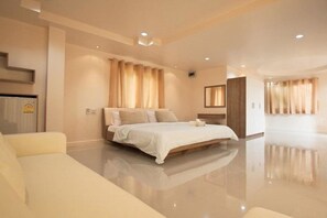 Una habitación de hotel moderna con una cama grande, una zona de estar y un baño.