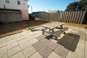 Ein Garten mit einem Holztisch und einer Beton-Terrasse.