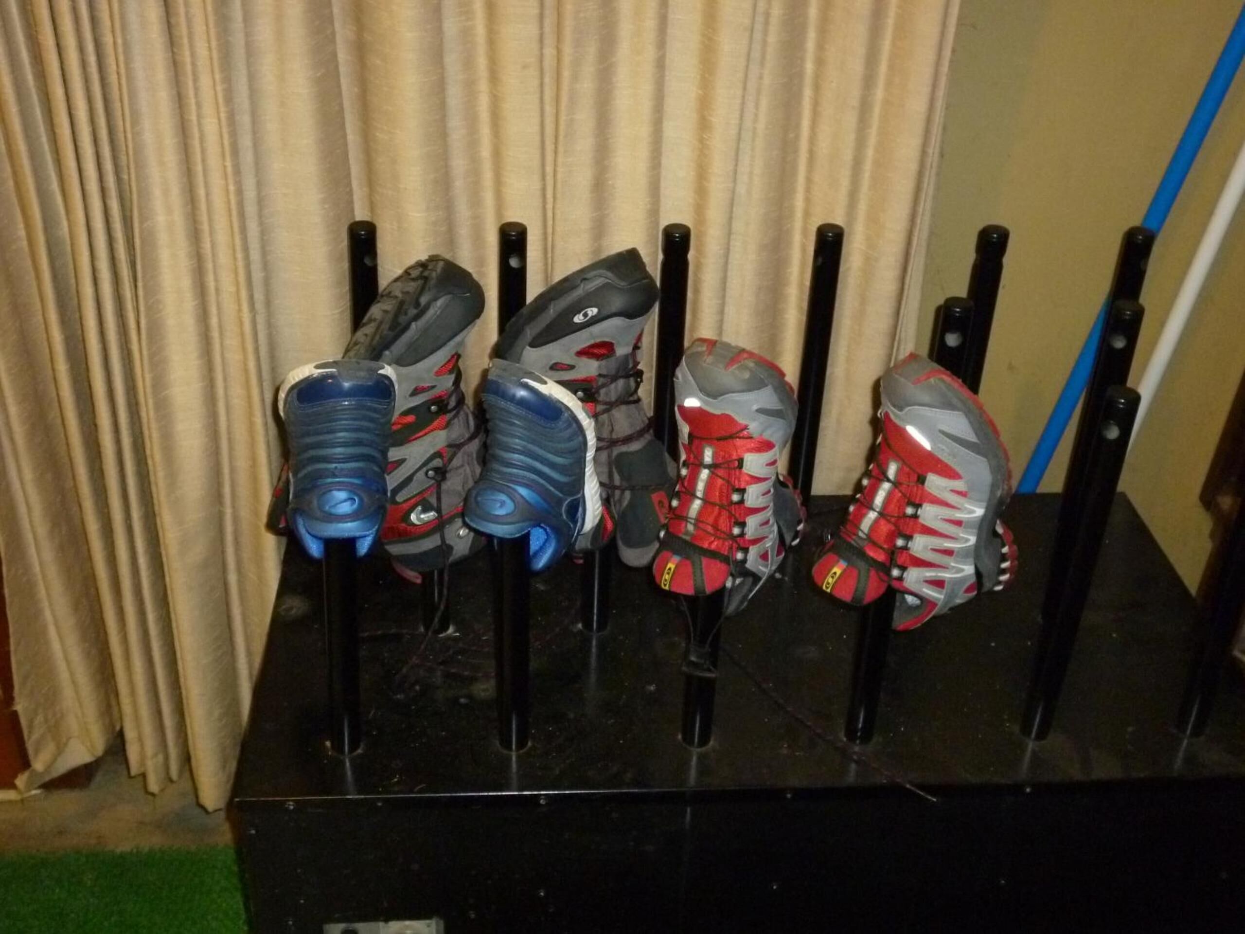 A rack of sports shoes with laces, arranged vertically.