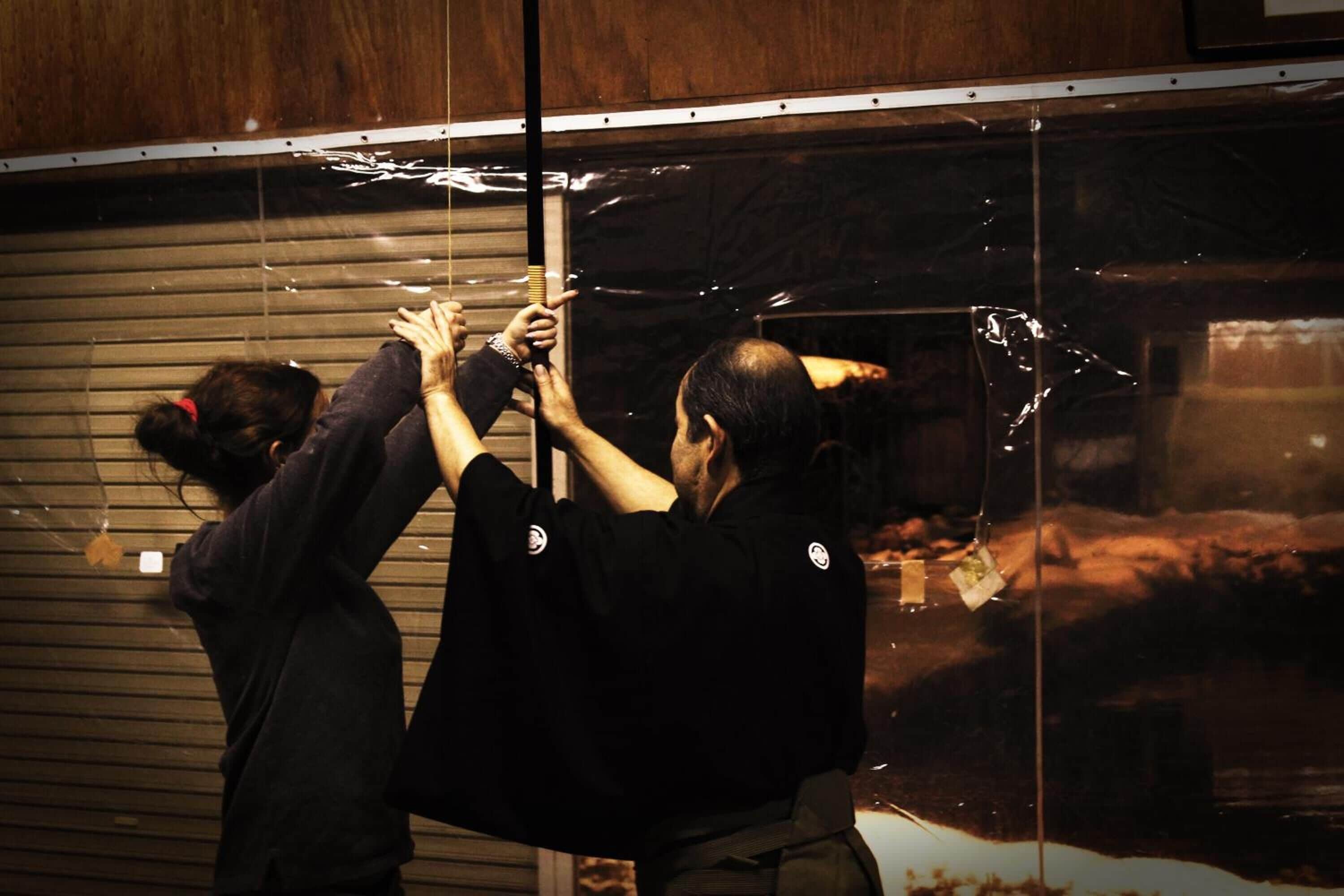 Two individuals installing a large glass panel.