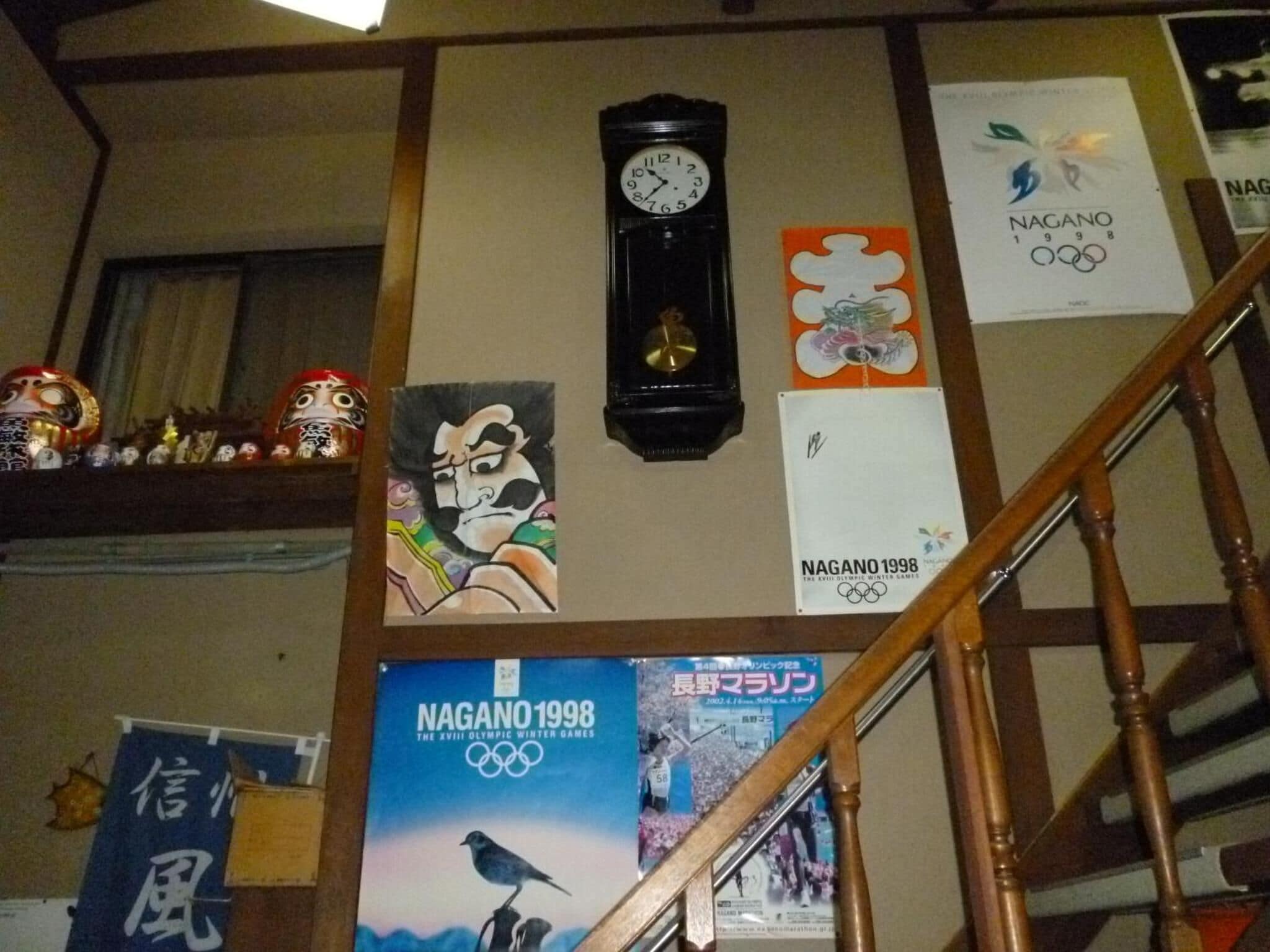 Una escalera con un reloj, carteles y decoraciones tradicionales japonesas.