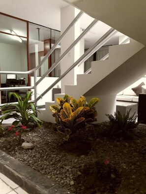 A modern interior with a staircase, indoor plants, and a tiled floor. - Bon Repos Arequipa (Arequipa)