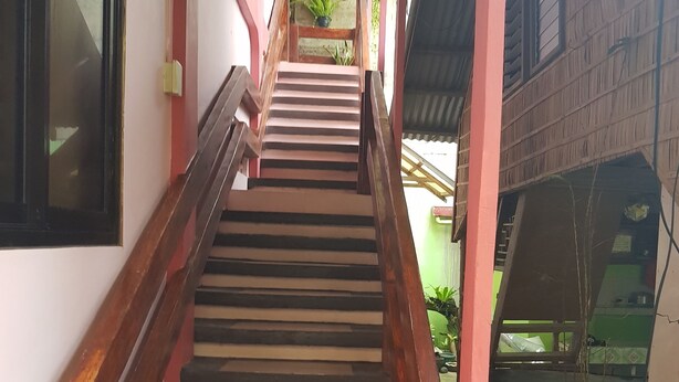 A staircase with wooden railings leading to a covered area with a green wall and a window. - Desiree's Lodge And Transient House, Baler Aurora (Baler)