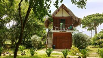 Una casa de madera con techo de paja, un balcón y un letrero que dice "LA SEGUNDA".