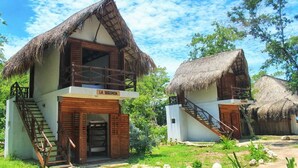 Un bungalow avec un toit de chaume, un escalier en bois et une enseigne sur laquelle on peut lire « LA SEGUNDA ».