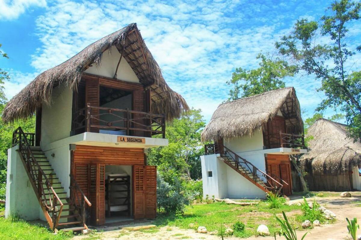 Un bungalow avec un toit de chaume, un escalier en bois et une enseigne sur laquelle on peut lire « LA SEGUNDA ».