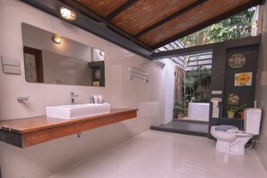 Um banheiro moderno com toucador de madeira, um espelho grande e vaso sanitário.