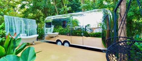 A trailer with a bathtub and a hammock.