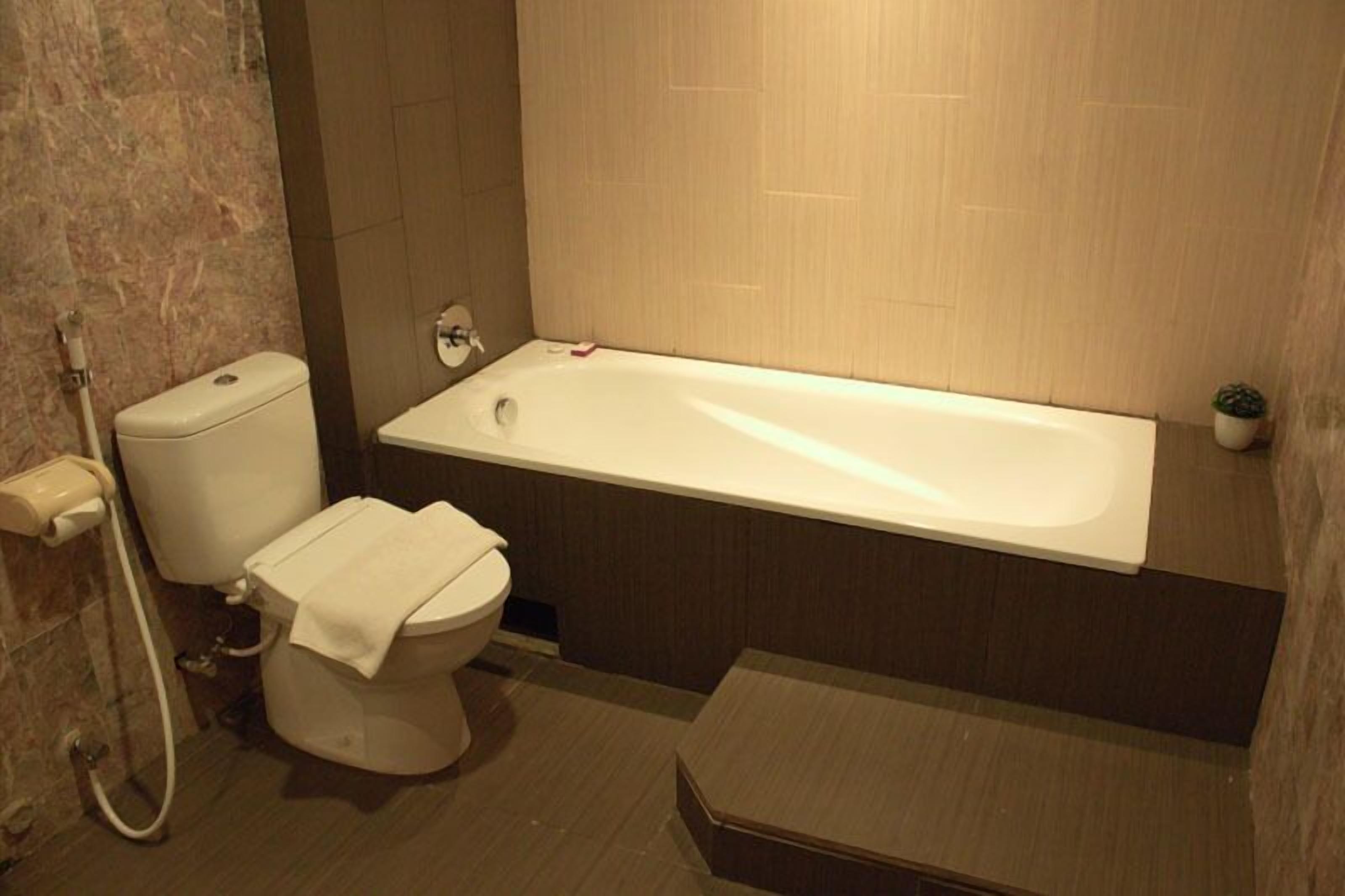 Ein Badezimmer mit Toilette, Badewanne und Dusche.