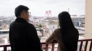Two people overlooking a cityscape with visible buildings and signage. - Ayola Sentosa Palembang (Palembang)