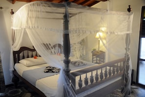 A four-poster canopy bed with a wooden frame and white bedding. - Banja Little Villa (Hikkaduwa)