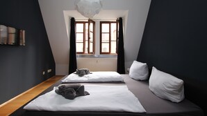 A modern hotel room with two beds, a large window with curtains, a flat-screen TV mounted on the wall, and a unique spherical light fixture. - DRUSCHBA Boutique Apartment (Leipzig)
