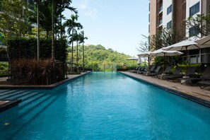 Relax by the rectangular pool surrounded by a deck and lush greenery.