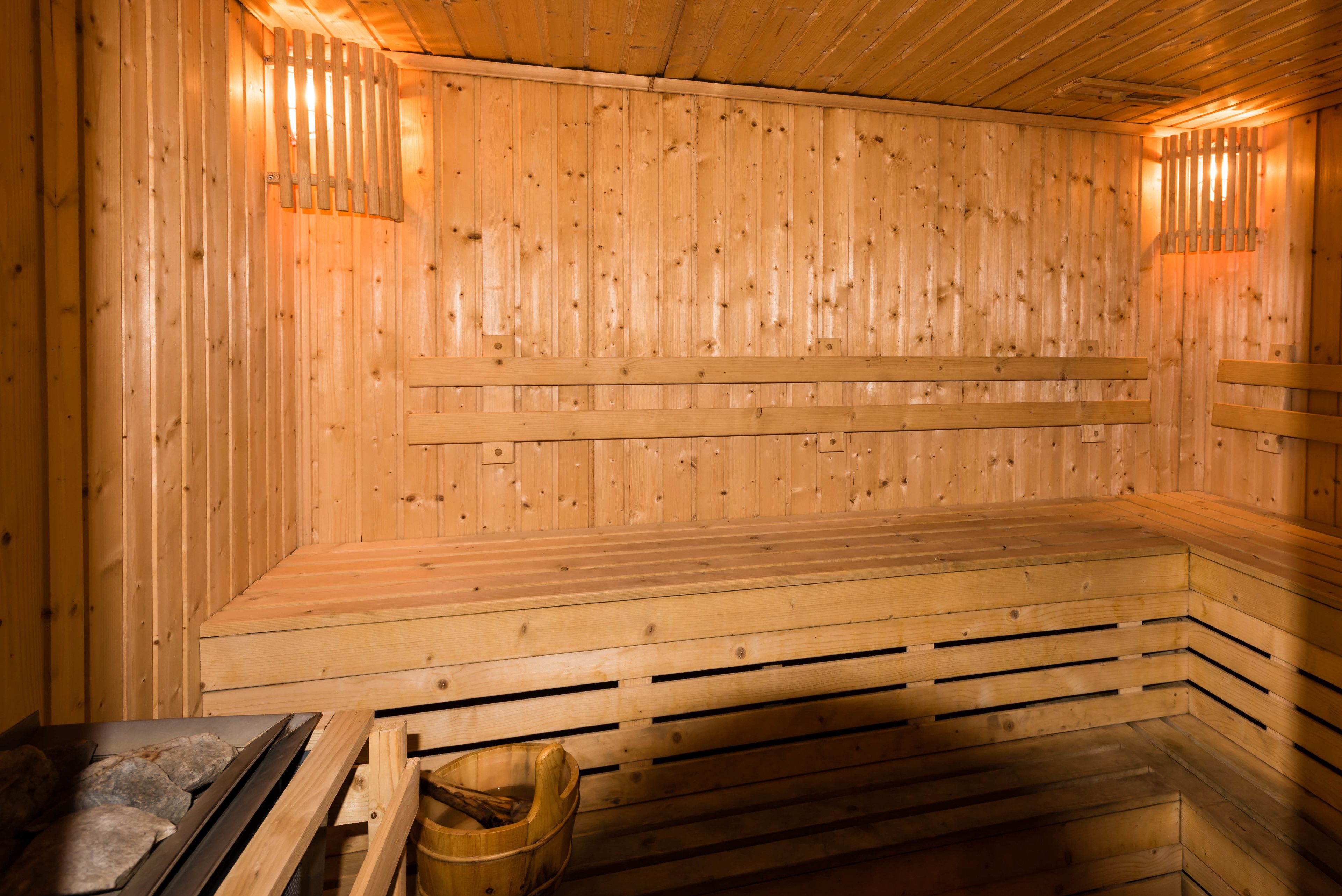 Un sauna en bois, doté de bancs et d’un système de chauffage à pierres.