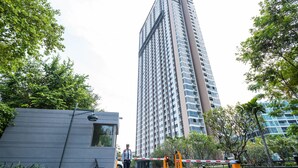 A tall residential building with a modern design, surrounded by greenery and a gated entrance. - Unixx South Pattaya by GrandisVillas (Pattaya)