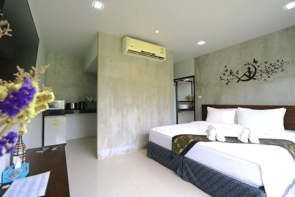 Une chambre d’hôtel moderne équipée d’un lit, d’une petite kitchenette et d’un élément décoratif mural.